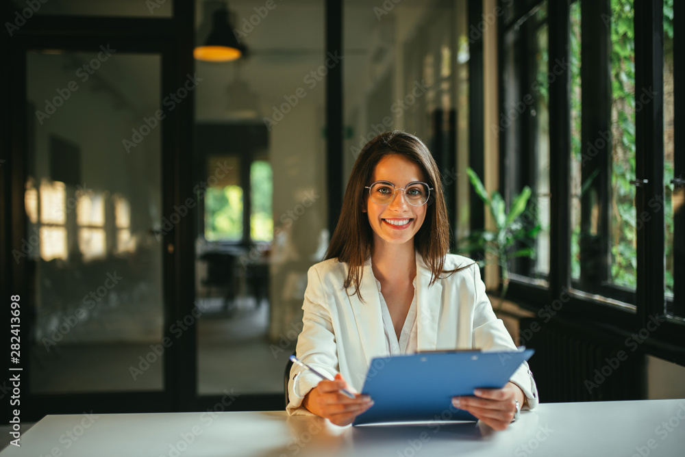 一位年轻积极的女性求职者手持文件的肖像