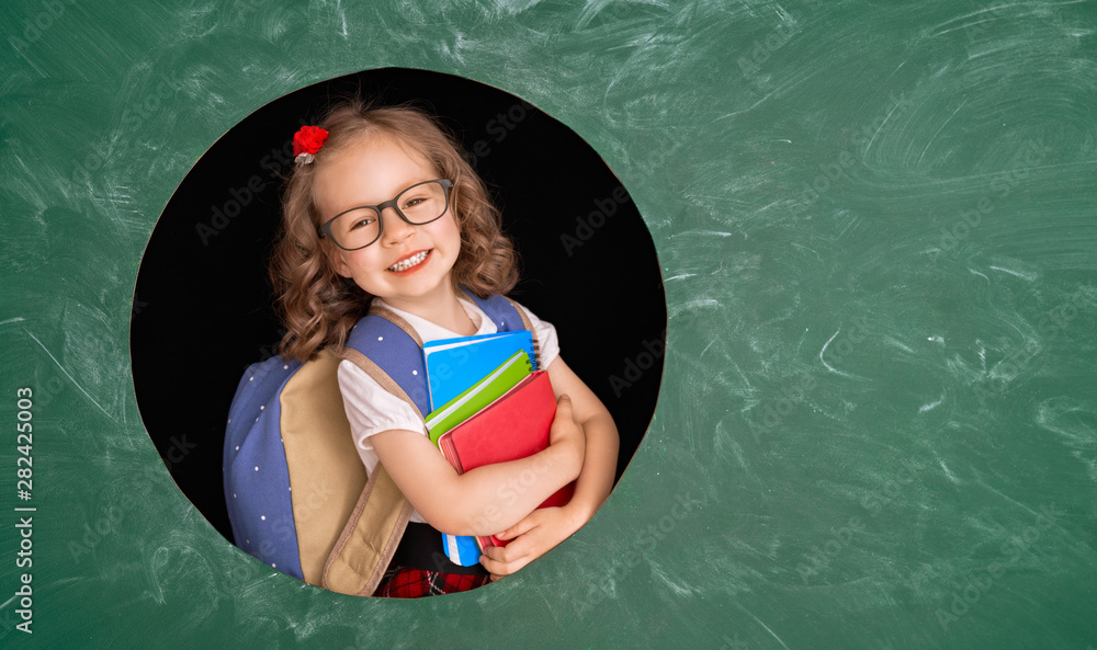 Kid in class on background of blackboard.