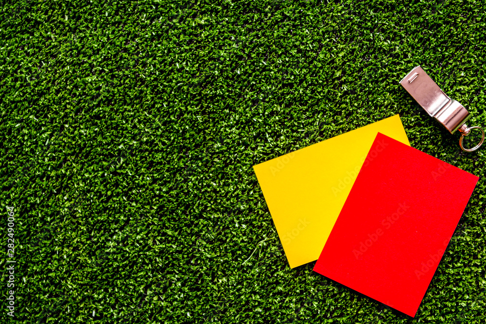 red and yellow cards on green background top view