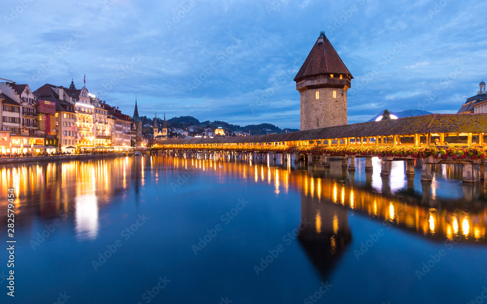 Old wooden architecture called Chapel Bridge in Luzern or Lucerne, Switzerland during sunset and twi