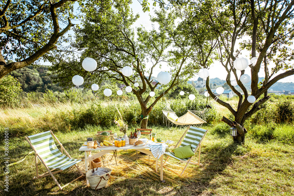 Beautifully decorated yard with sunbeds, table, hammock and decorative lanterns, ready for the festi