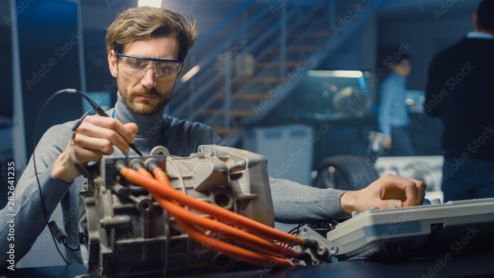 Professional Automotive Engineer in Glasses with a Computer and Inspection Tools is Testing an Used 