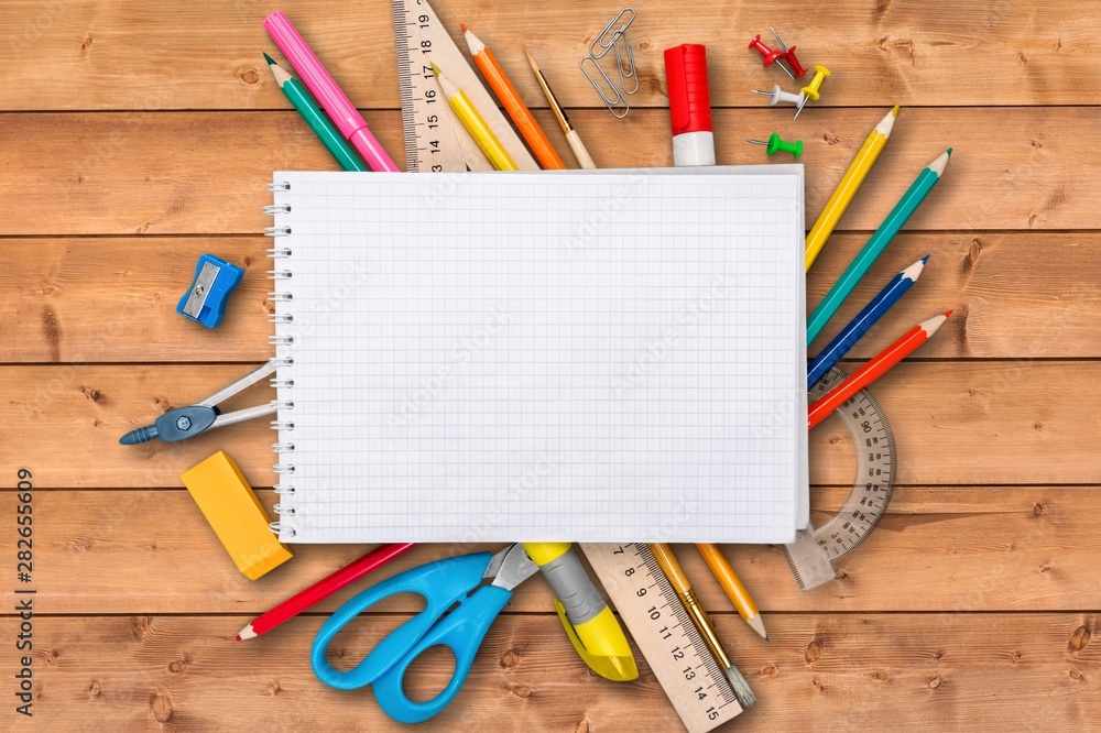 Colorful school supplies on wooden table background