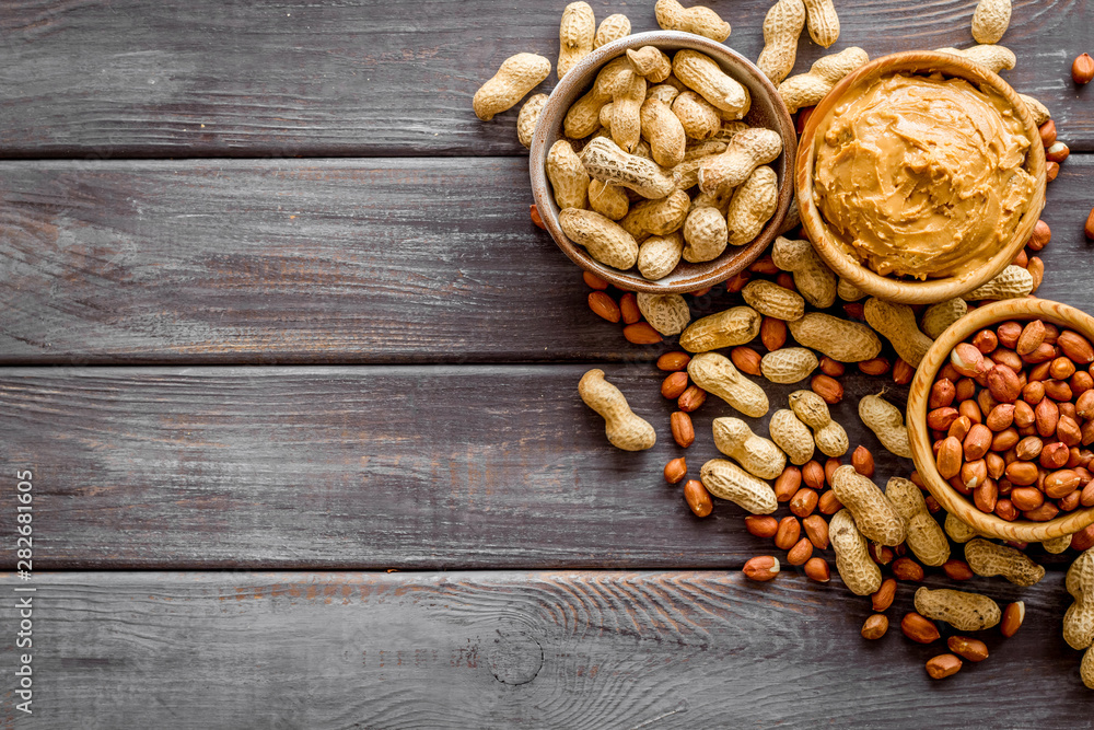 nuts in bowl for peanut butter for cooking breakfast at home on wooden background top view mock-up