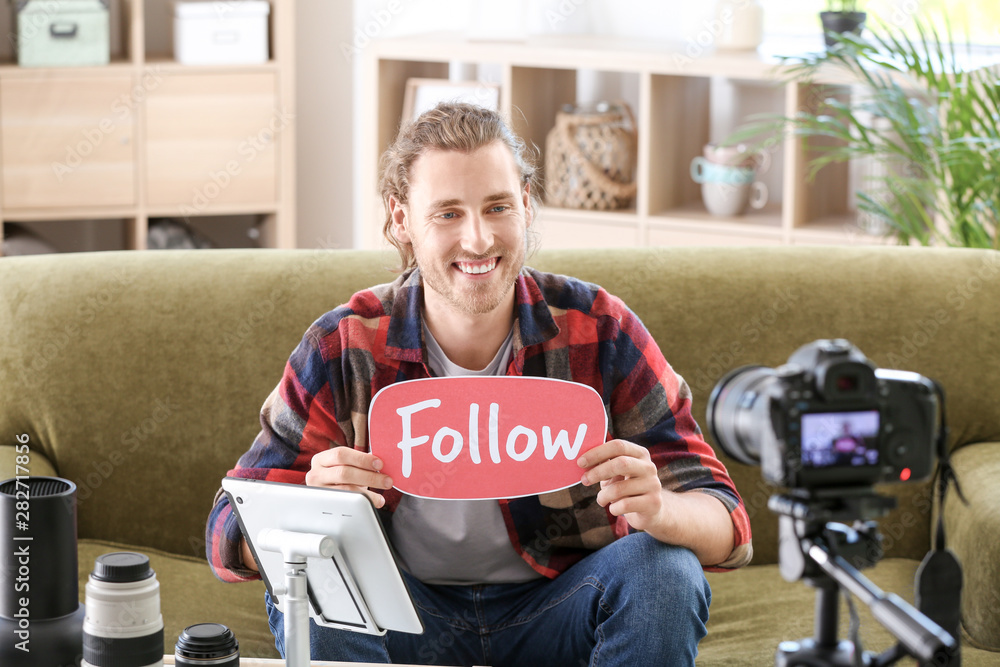 Male photographer recording video for his blog at home