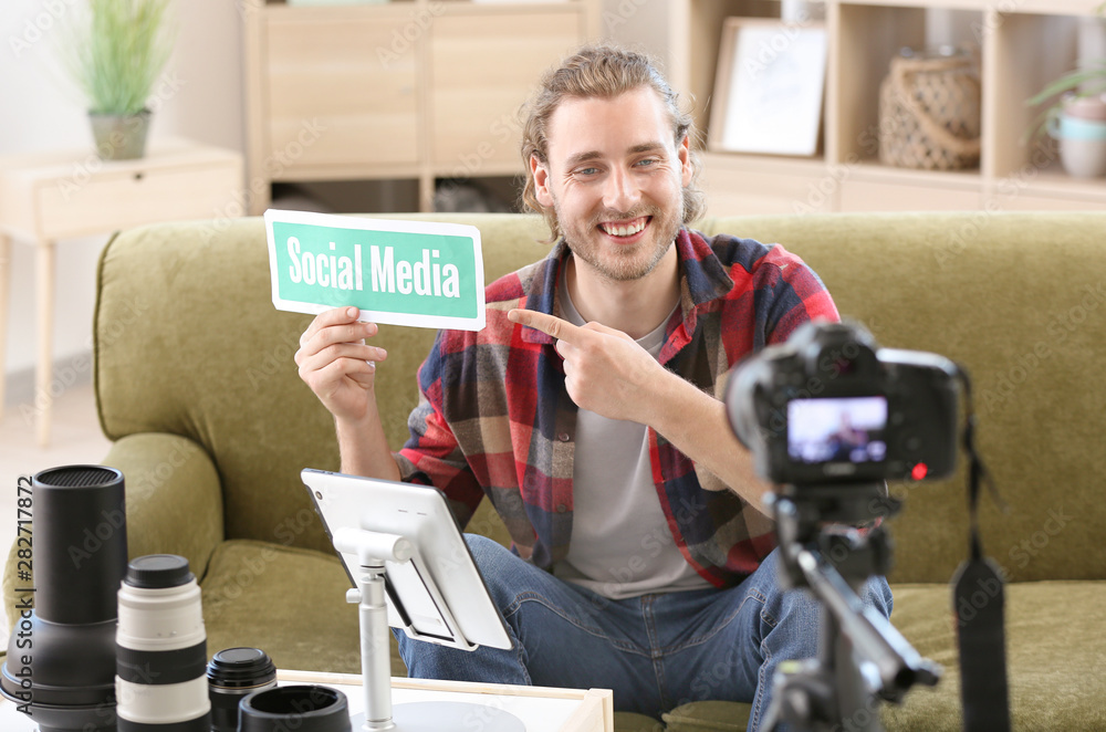 Male photographer recording video for his blog at home