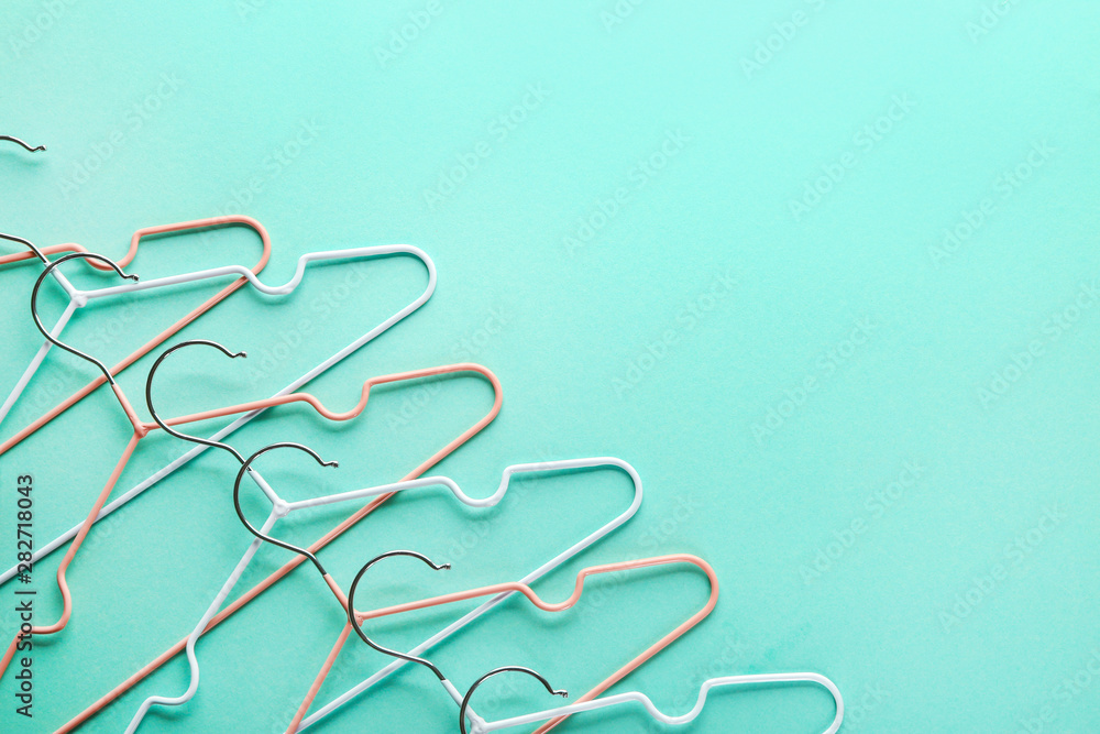 Many clothes hangers on color background