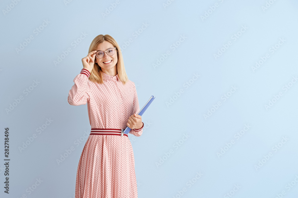 Beautiful female teacher on color background