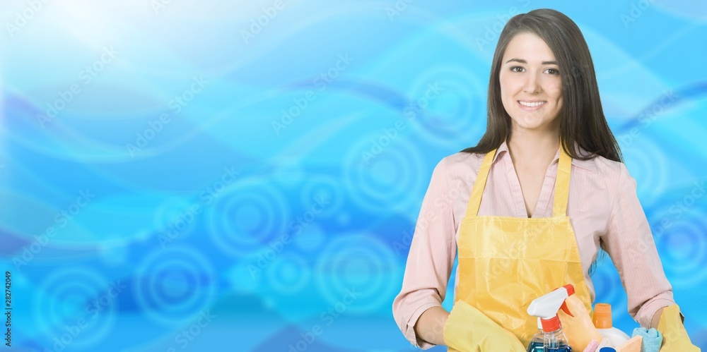 Young woman housewife with a bucket of cleaning products