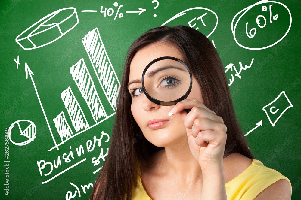 Beautiful woman looking through a magnifying glass