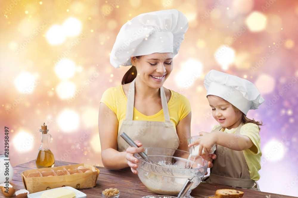 Portrait of adorable little girl and her mother baking together