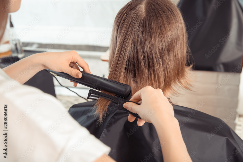 Female hairdresser working with client in salon, closeup