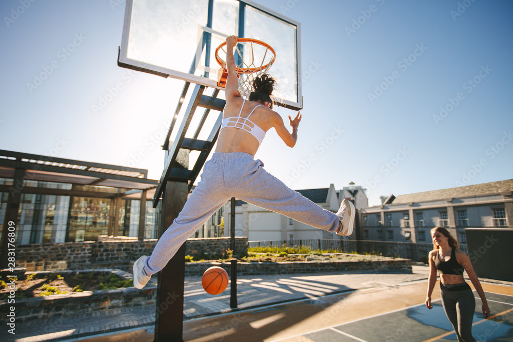 Females playing basketball on street court