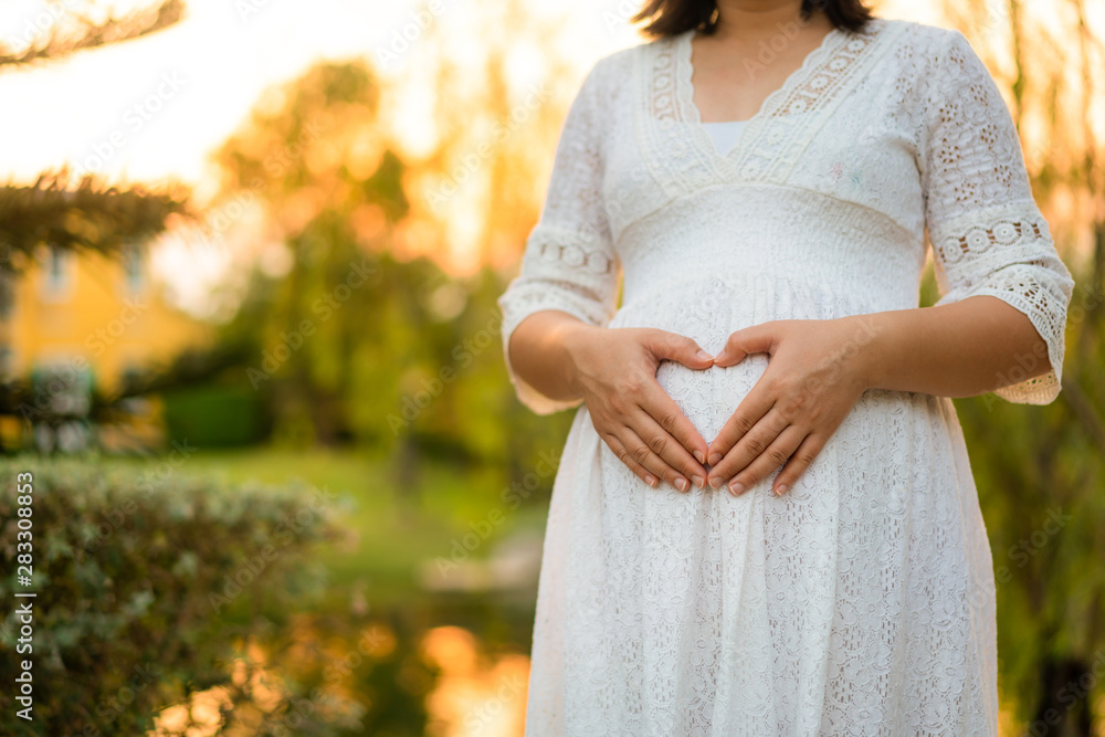 孕妇在花园里照顾孩子，对新生活感到幸福。年轻的前男友