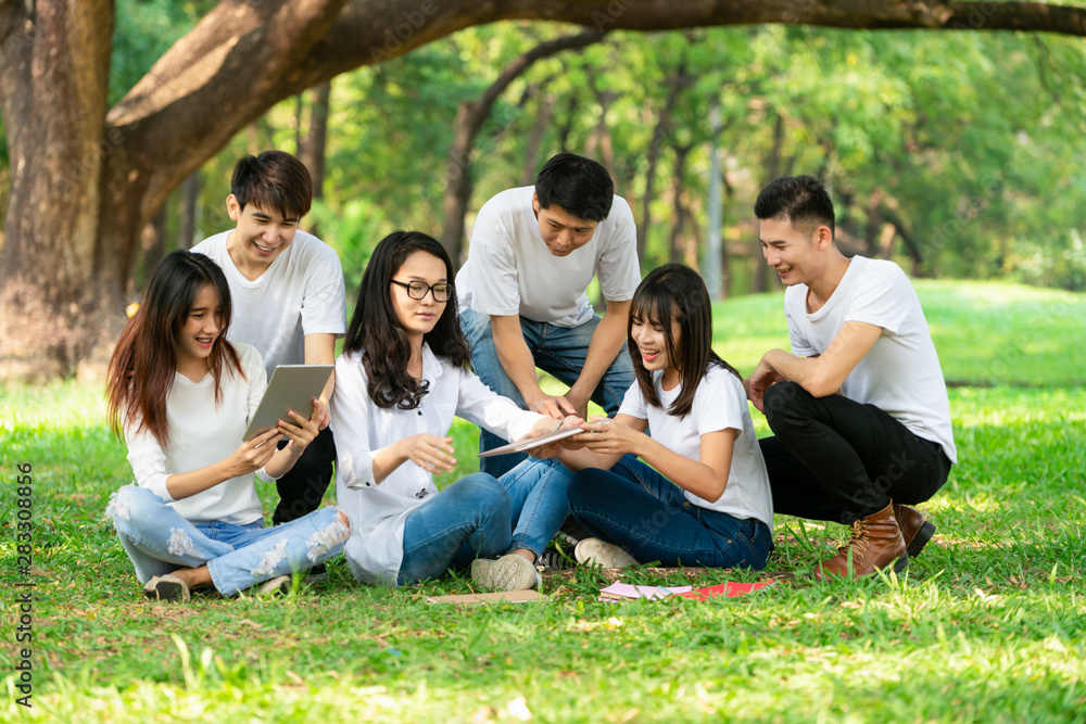 在大学或学校公园的小组项目中学习的年轻学生团队。快乐学习