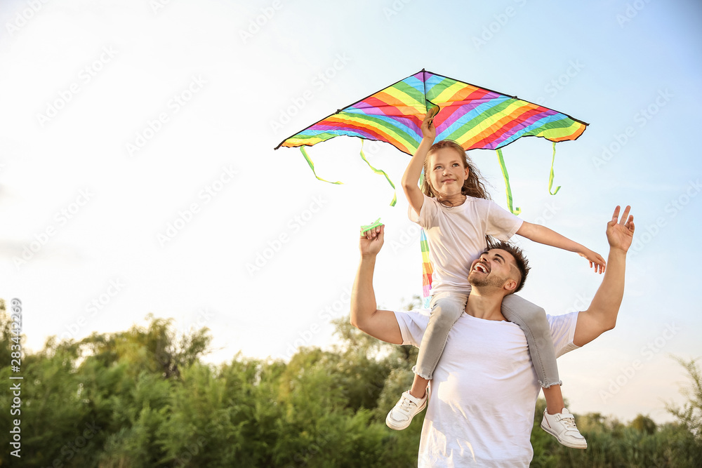 年轻人带着小女儿在户外放风筝