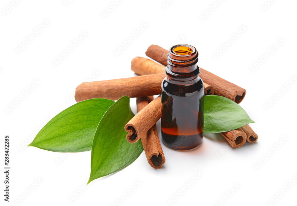 Aromatic cinnamon sticks and essential oil on white background