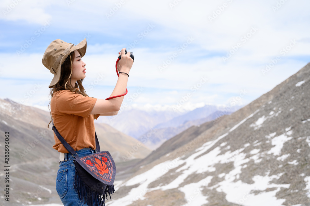 Portrait of young Asian woman talking photos on snow mountain, outdoors and traveller concept