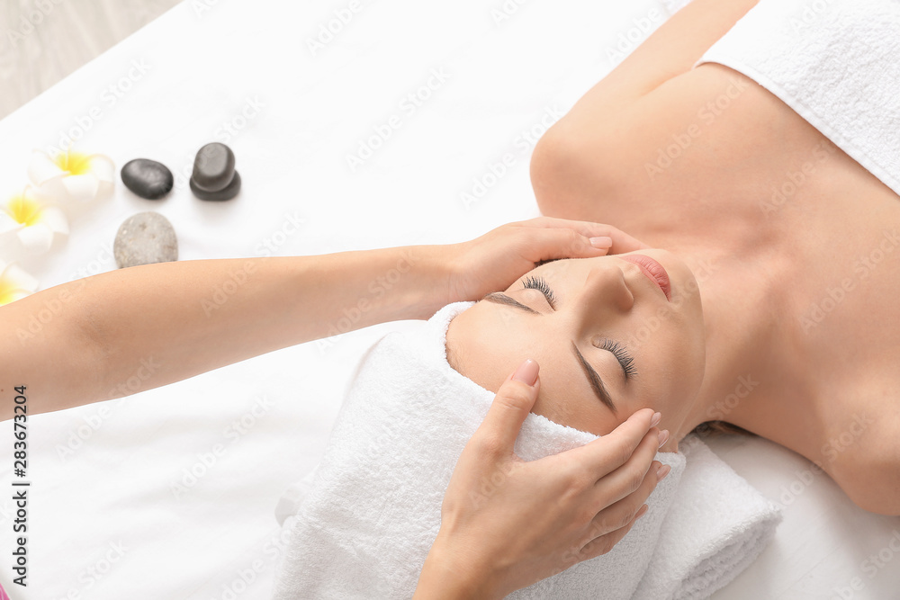 Young woman having facial massage in beauty salon