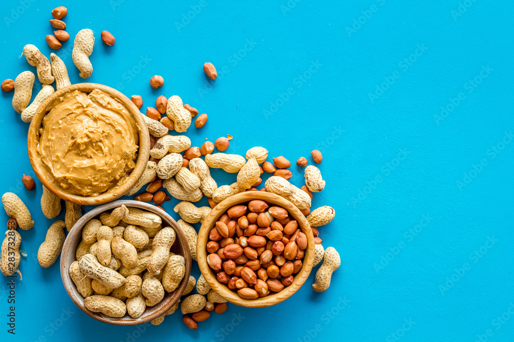 nuts in bowl for peanut butter for cooking breakfast at home on blue background top view mock-up