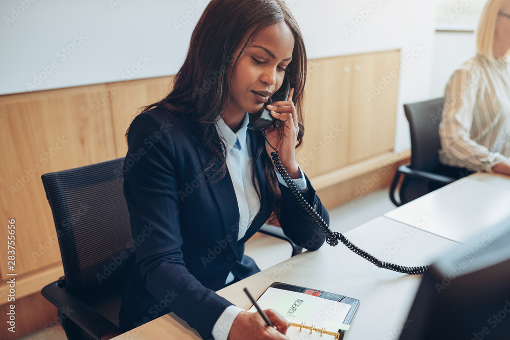 African American businesswoman taking phone messages in an offic