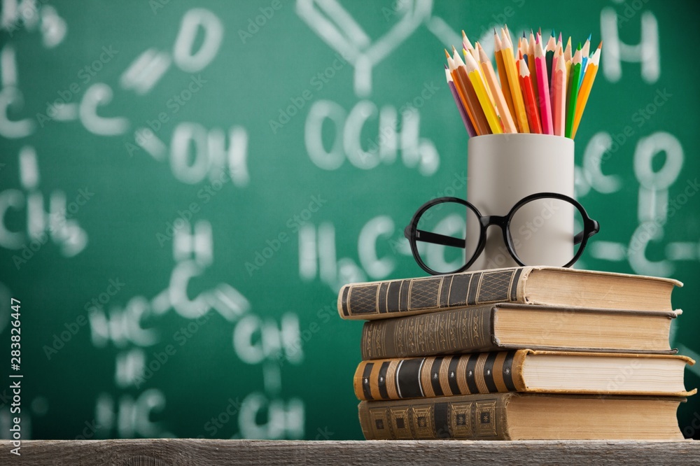 Stack of vintage books, eyeglasses and pencils, education and learning