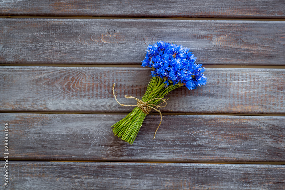 Summer design for blog with bouquet of blue cornflowers on wooden background top view copyspace