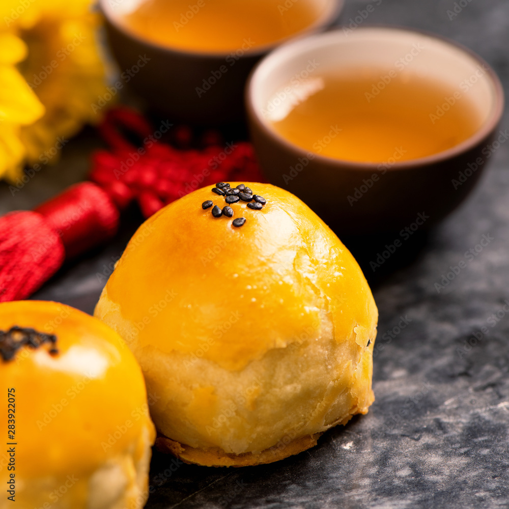 Tasty baked egg yolk pastry moon cake for Mid-Autumn Festival on black slate dark background. Chines