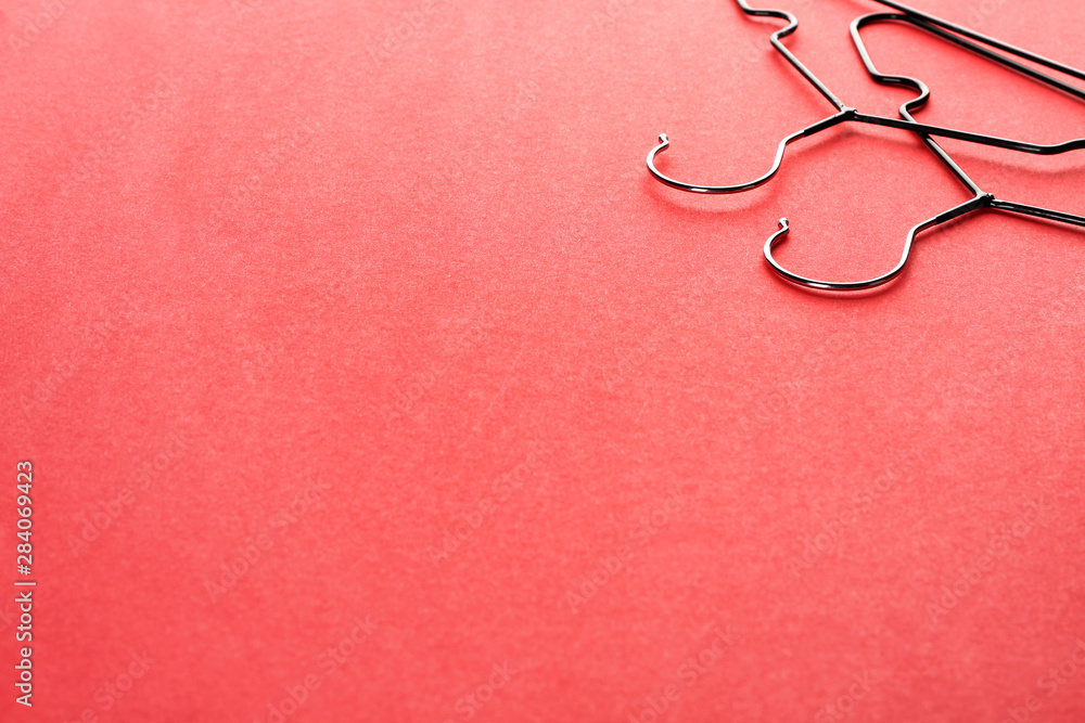 Clothes hangers on color background