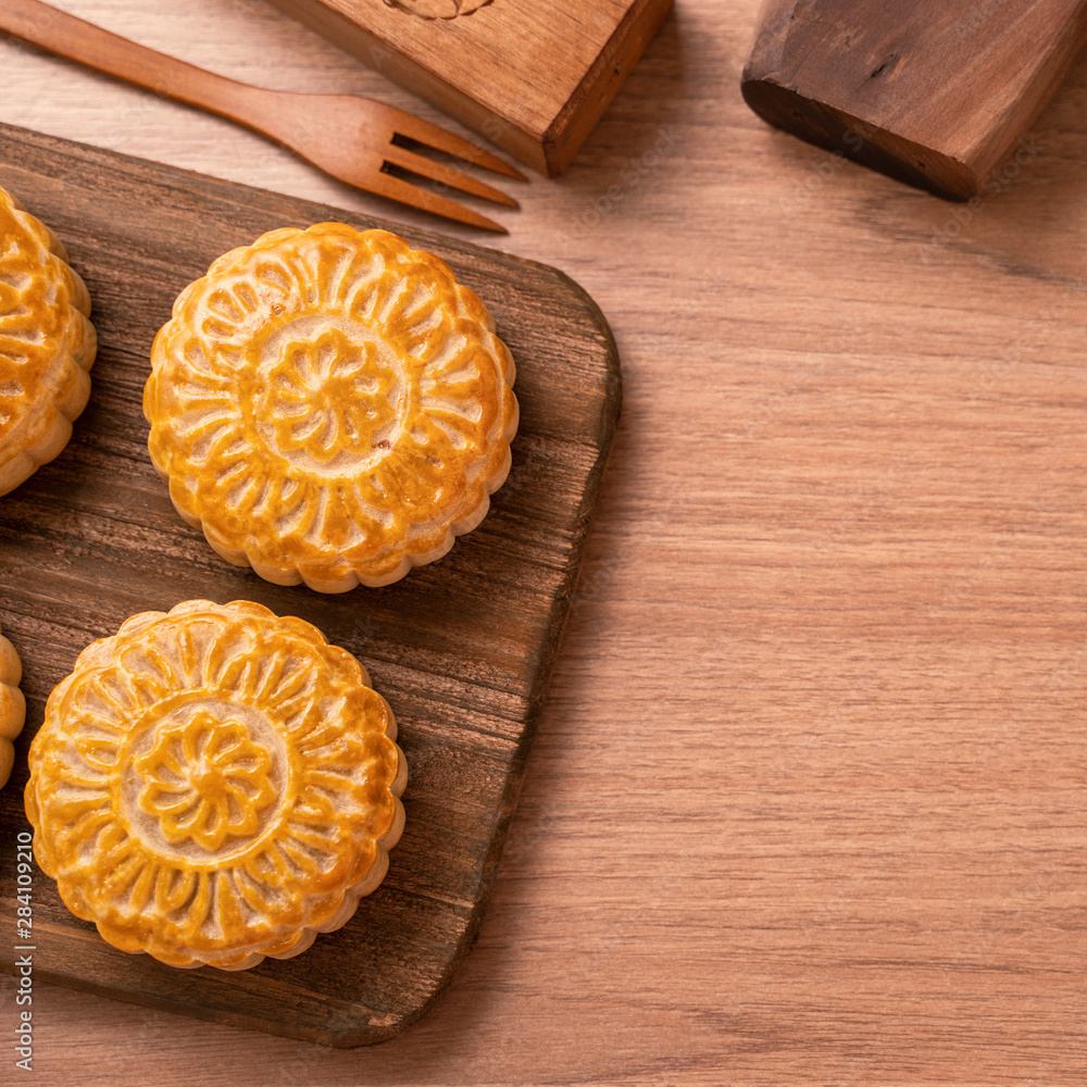 Round shaped fresh baked moon cake pastry - Chinese moonckae for Mid-Autumn Moon Festival on wooden 