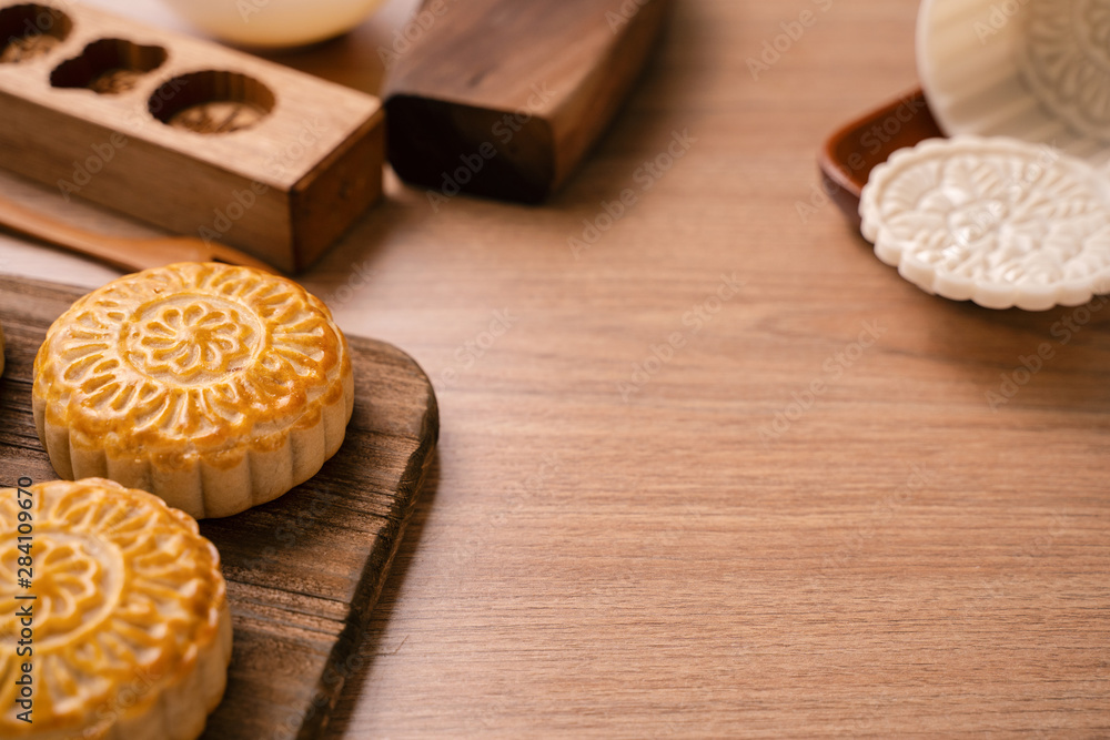 Round shaped fresh baked moon cake pastry - Chinese moonckae for Mid-Autumn Moon Festival on wooden 