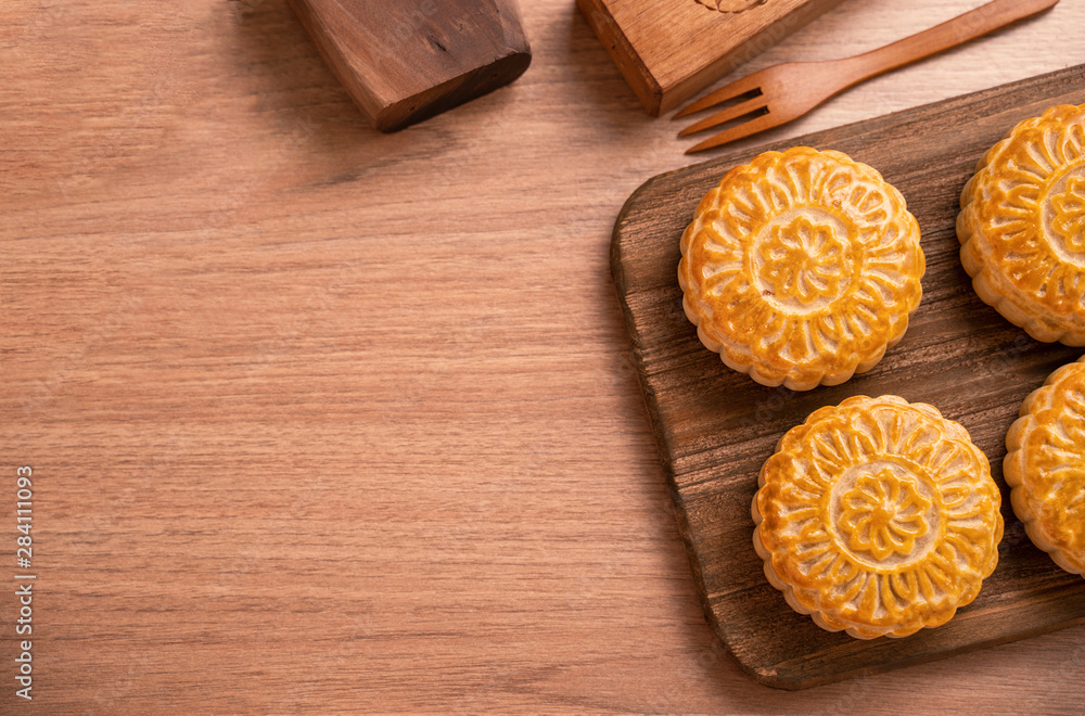 Round shaped fresh baked moon cake pastry - Chinese moonckae for Mid-Autumn Moon Festival on wooden 