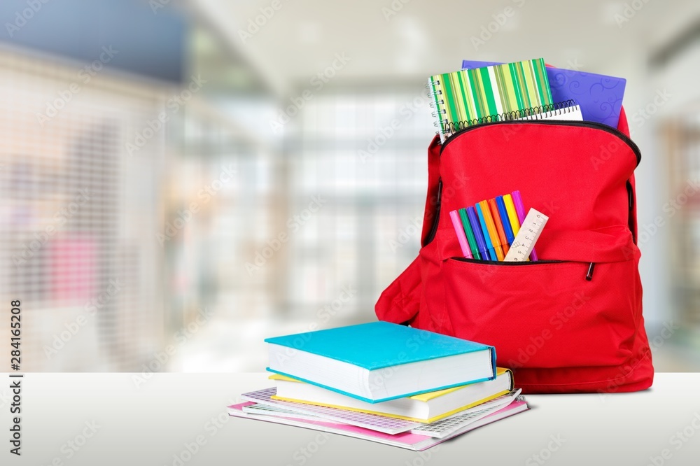 School Backpack with stationery on wooden table