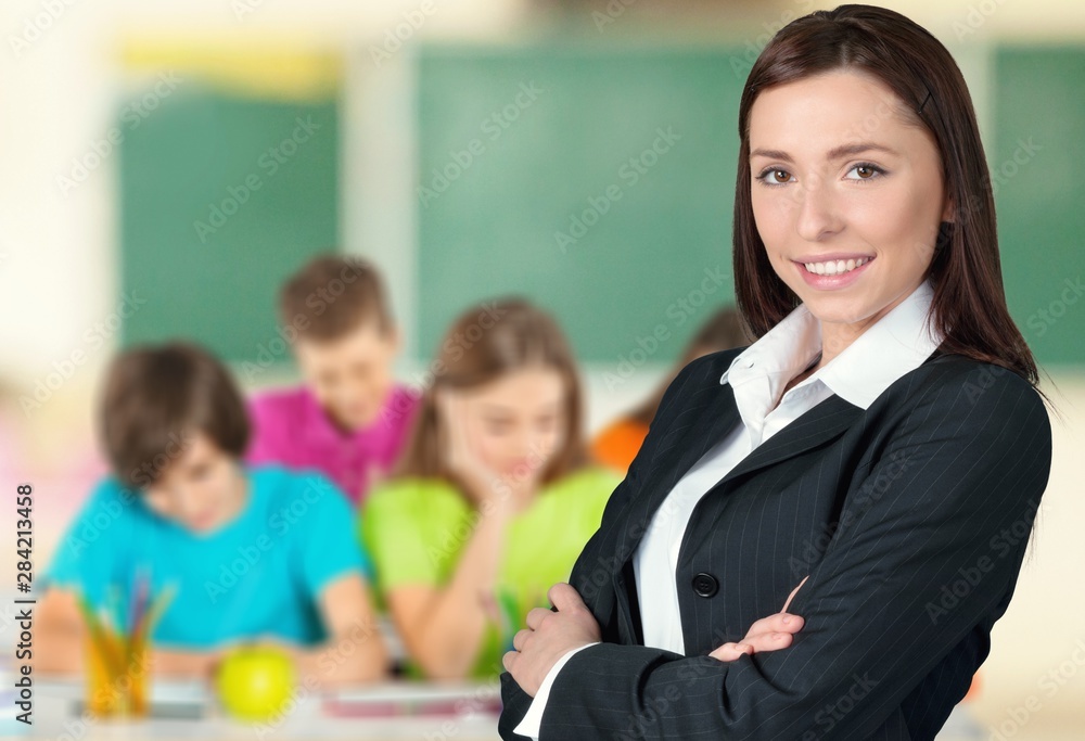 Young female teacher with students in classroom