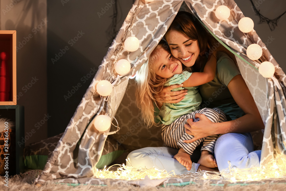 Happy mother and her little daughter in hovel at home