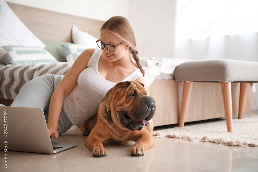 Happy woman with cute dog working at home