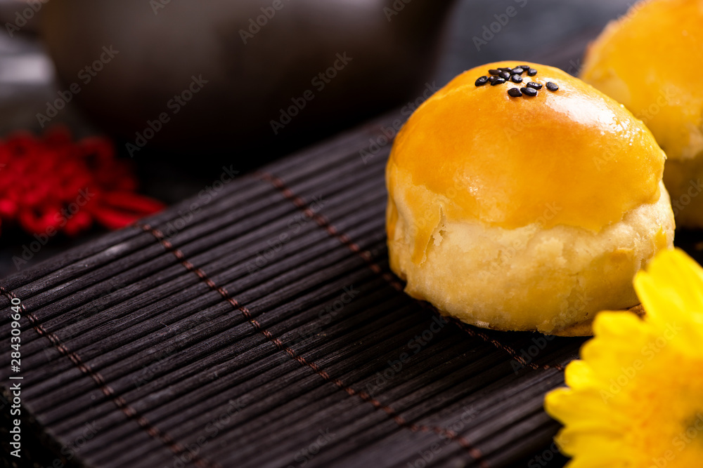 黑石板深色背景，美味的中秋蛋黄酥月饼。中国