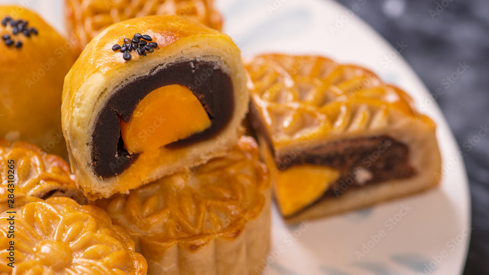 Tasty baked egg yolk pastry moon cake for Mid-Autumn Festival on black slate dark background. Chines