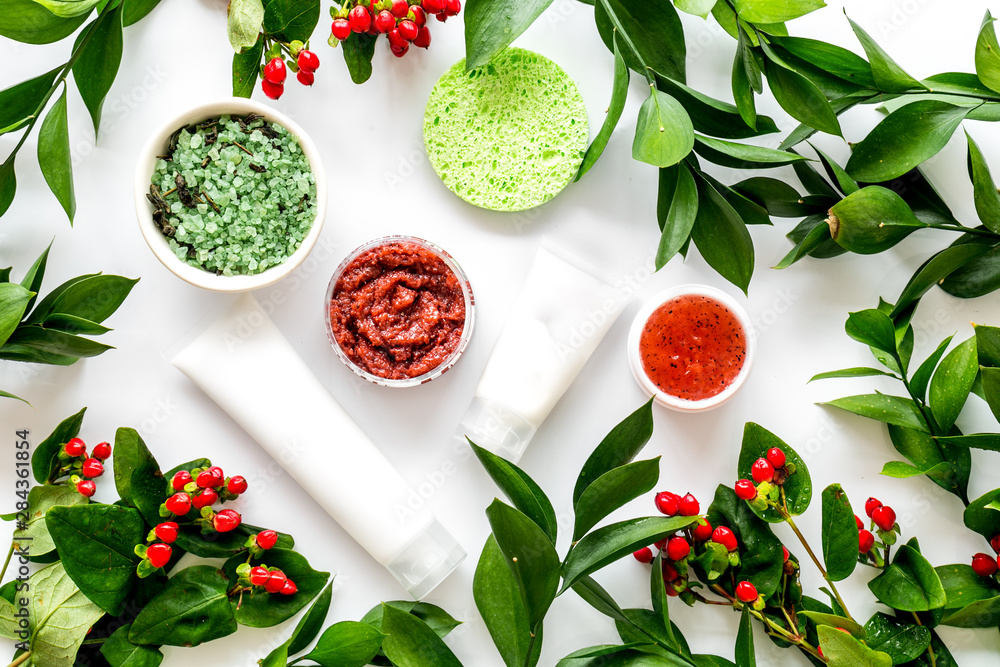 Cosmetics for face with salt, lotion, cream from herbs on white background top view