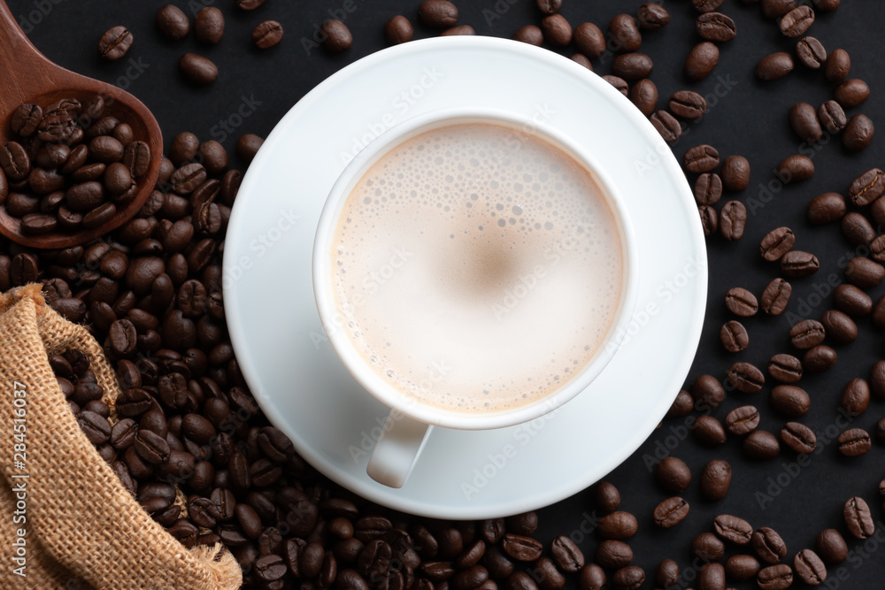 Cappuccino or latte with foaming foam and coffee beans, white coffee cups on the table, top view