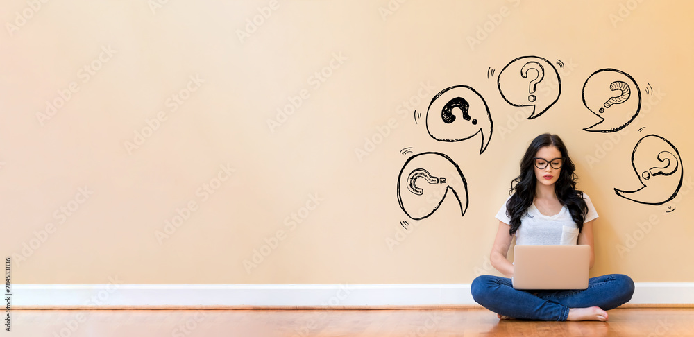 Question marks with speech bubbles with young woman using a laptop computer