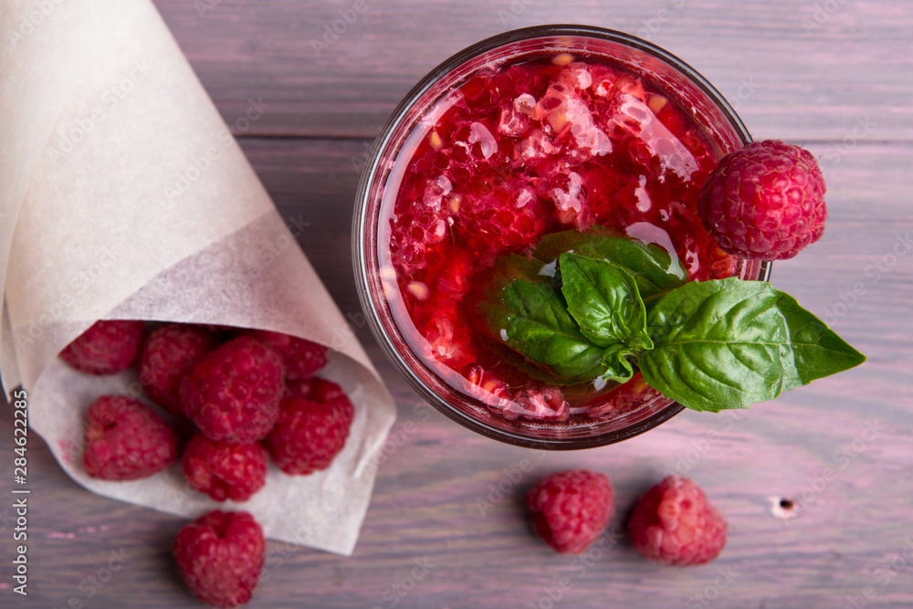 Glass of fresh strawberry smoothie and fresh strawberries on pink wooden background. Healthy food an