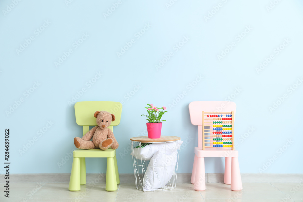 Chairs and table near color wall in childrens room