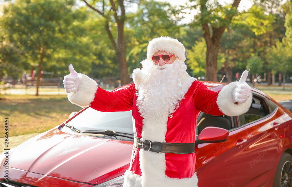 Santa Claus showing thumb-up gesture near car outdoors