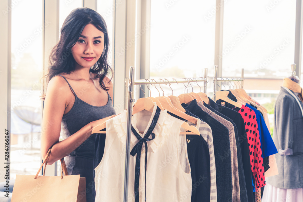 美丽的女人在购物中心的服装零售店买衣服。现代贸易生活