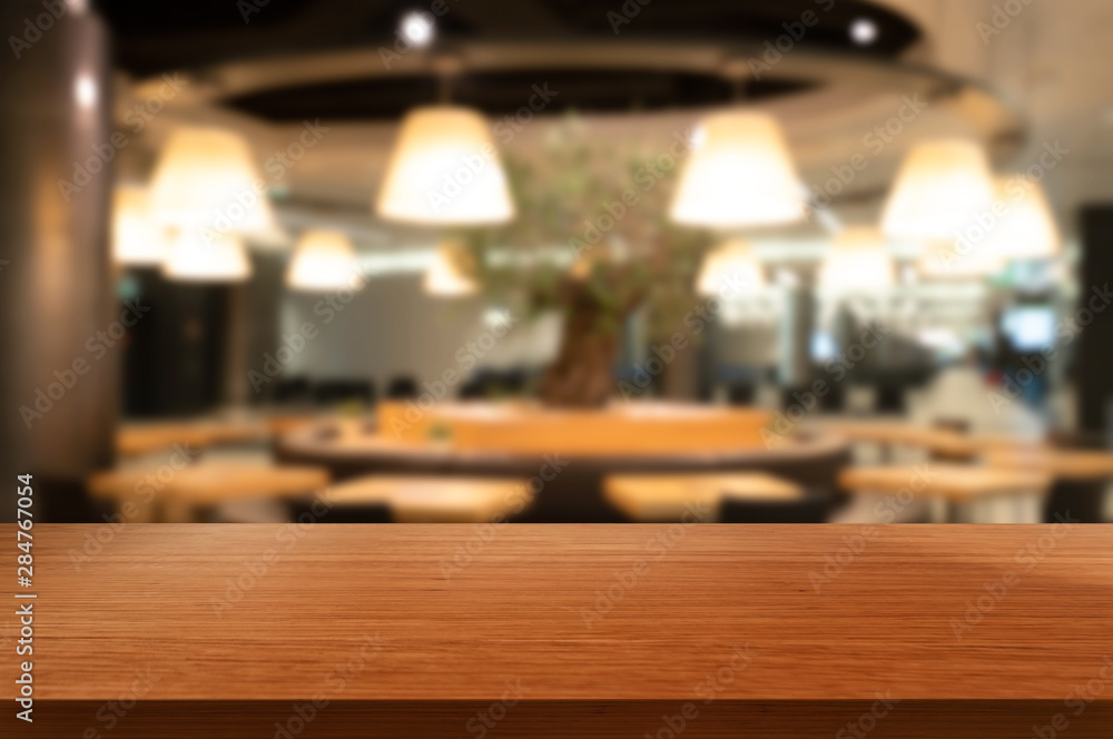 Wood table in blurry background of modern restaurant room or coffee shop with empty copy space on th