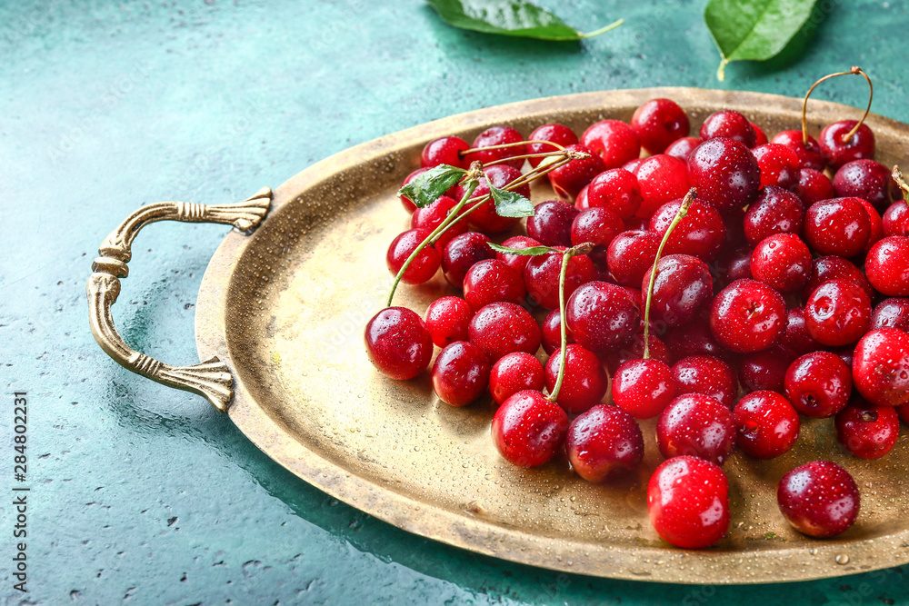 Tray with ripe sweet cherry on color background