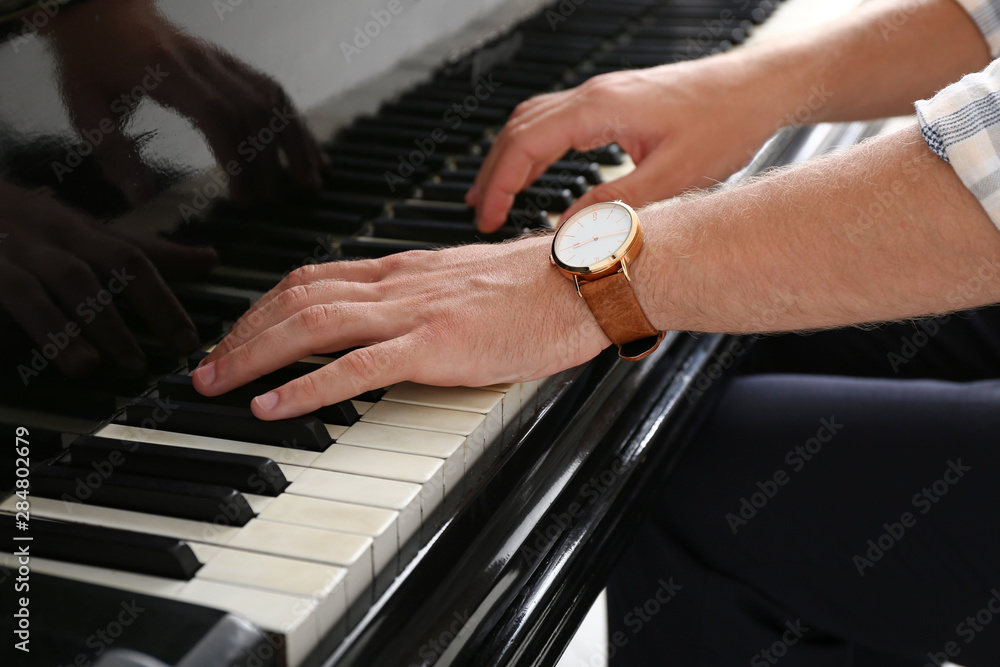 Man playing grand piano at the concert, closeup