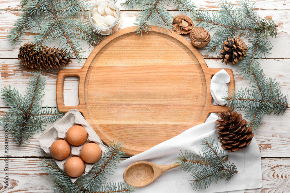 Wooden board with eggs and Christmas decor on table