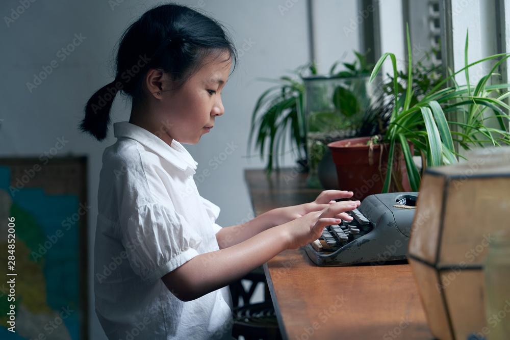 亚洲小女孩用老式打字机学习